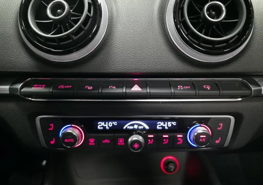 Détail du tableau de bord de l'Audi A3 Cabriolet 2015 montrant la climatisation automatique et les aérateurs ronds noirs.