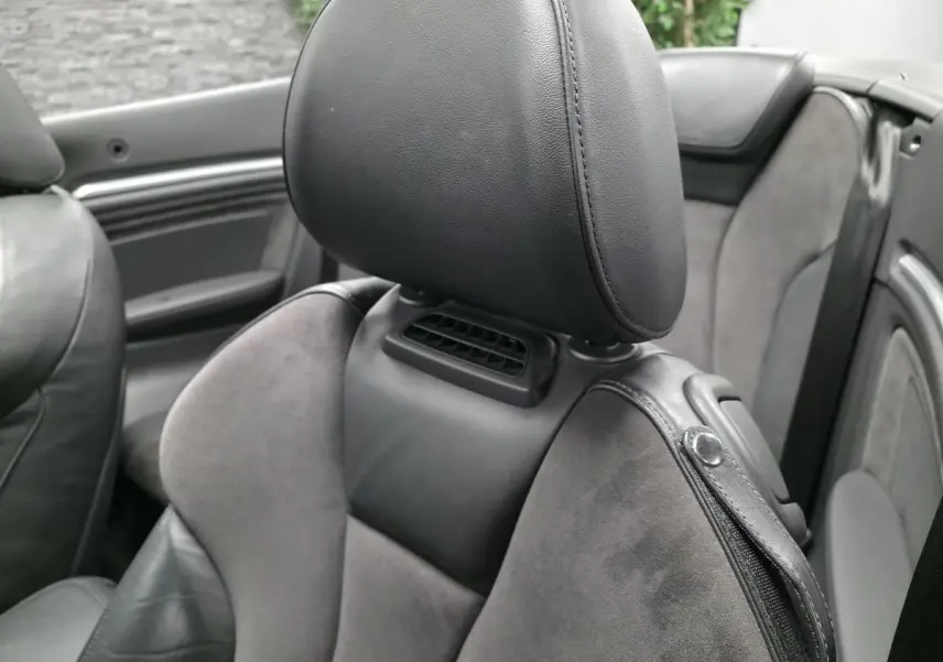 Gros plan sur le siège avant en alcantara et cuir gris foncé de l'Audi A3 Cabriolet 2015, intérieur ouvert.