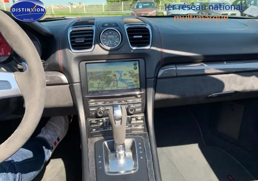Intérieur noir Alcantara de Porsche Boxster 981 vu du poste de conduite, avec console centrale et écran tactile visible.