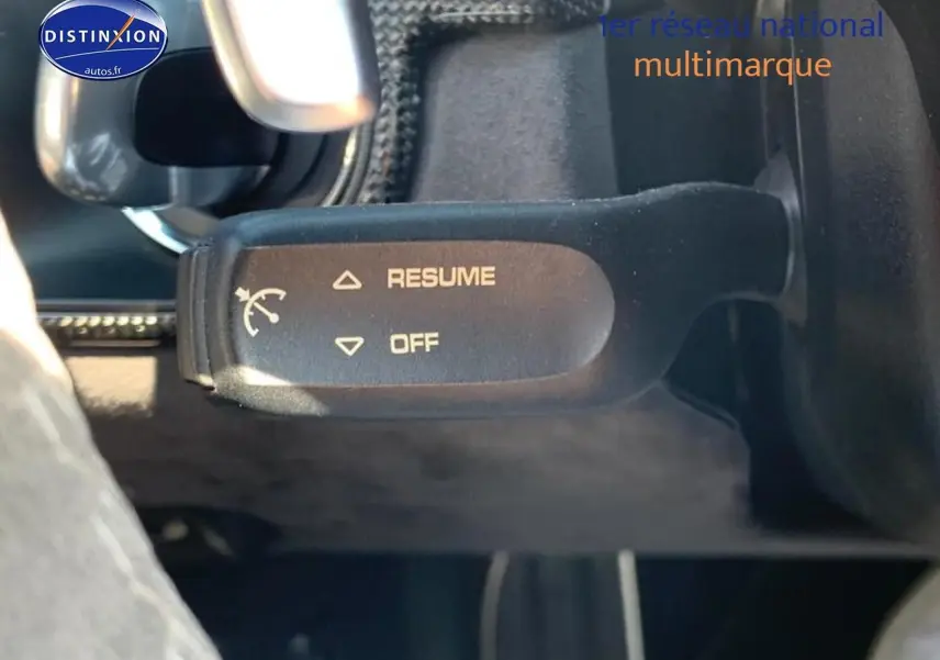 Gros plan sur la commande de régulateur de vitesse dans l'habitacle noir d'une Porsche Boxster 981 rouge.