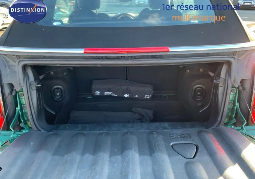 Coffre ouvert vu de l'arrière d'une MINI Cabriolet F57 2023 British Racing Green avec capote noire.