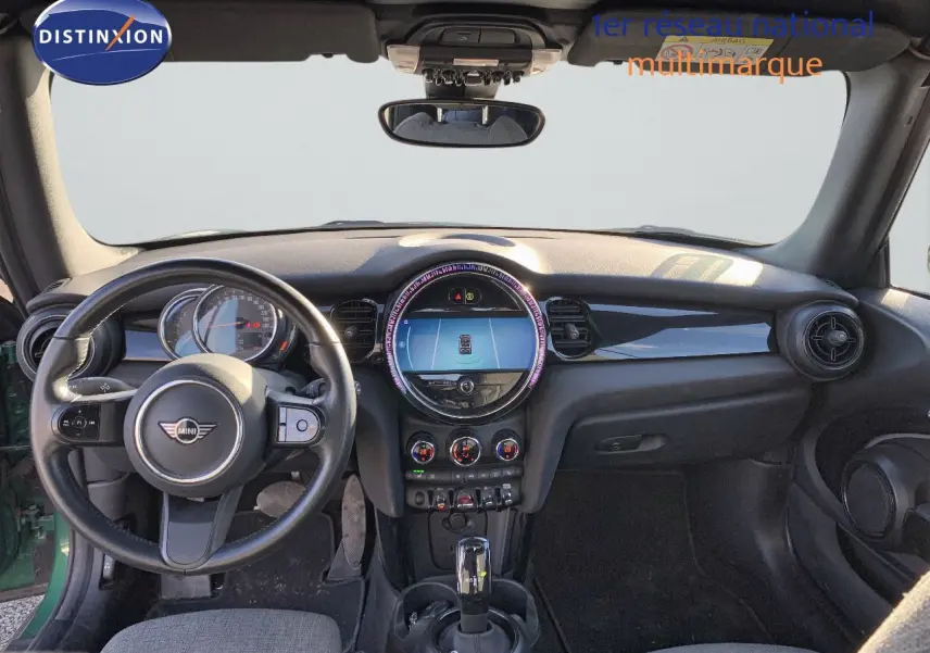 Vue intérieure frontale du tableau de bord et volant noir du MINI Cabriolet F57 vert British Racing 2023.