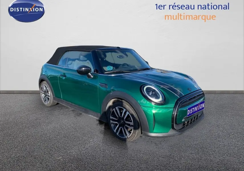 Vue 3/4 avant gauche d'une MINI Cabriolet 2023 British Racing Green avec toit noir fermé et jantes bi-ton.