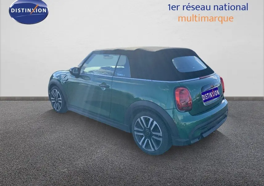 MINI Cabriolet F57 British Racing Green vue 3/4 arrière côté gauche avec toit souple noir fermé.