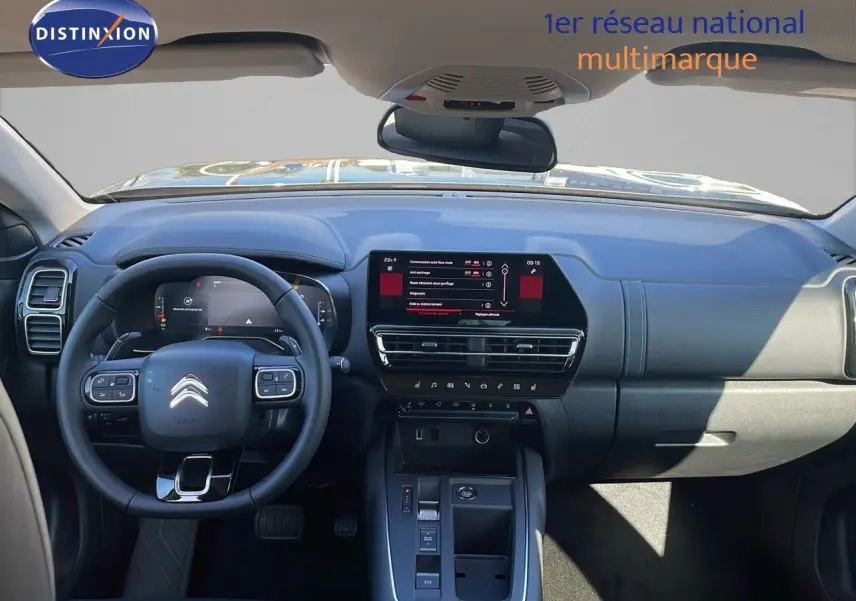 Vue intérieure frontale du tableau de bord noir du Citroën C5 Aircross 2025 avec écran tactile central et volant multifonction.