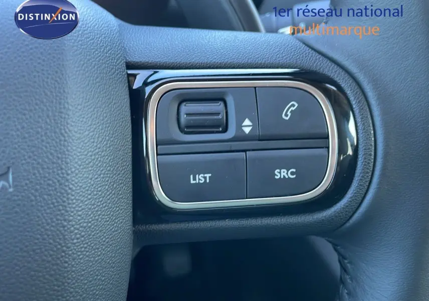 Gros plan sur les commandes gauche du volant du Citroën C5 Aircross gris platinium avec toit noir, modèle 2025.