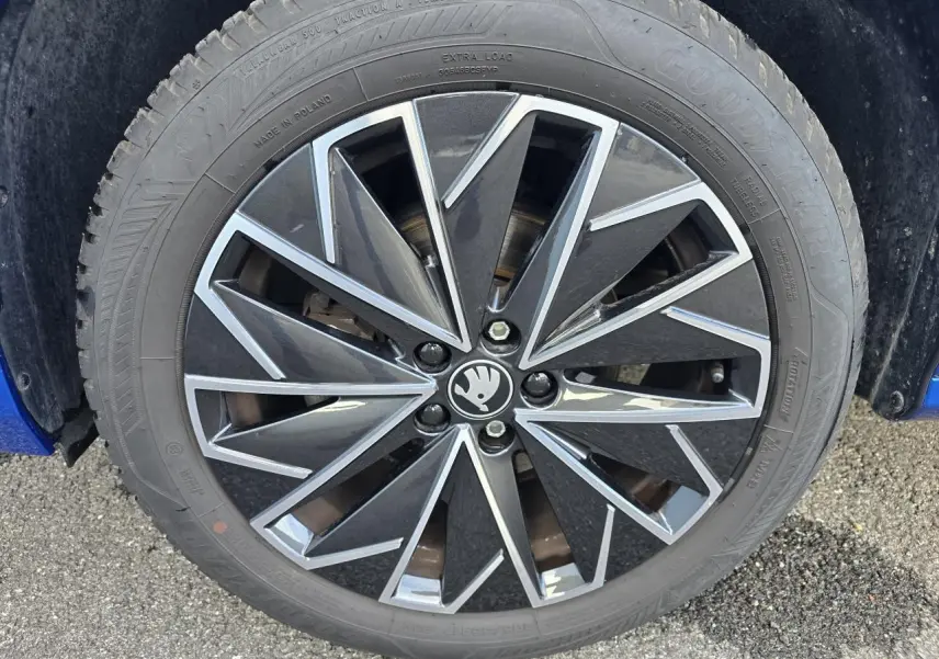 Gros plan sur la jante alliage 17 pouces noire et argentée du Skoda Kamiq bleu racing avec toit noir.