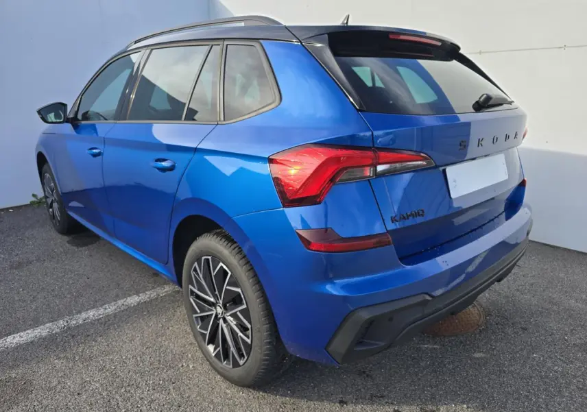 Vue 3/4 arrière droite d'un Skoda Kamiq bleu racing avec toit noir et jantes alliage 17 pouces.