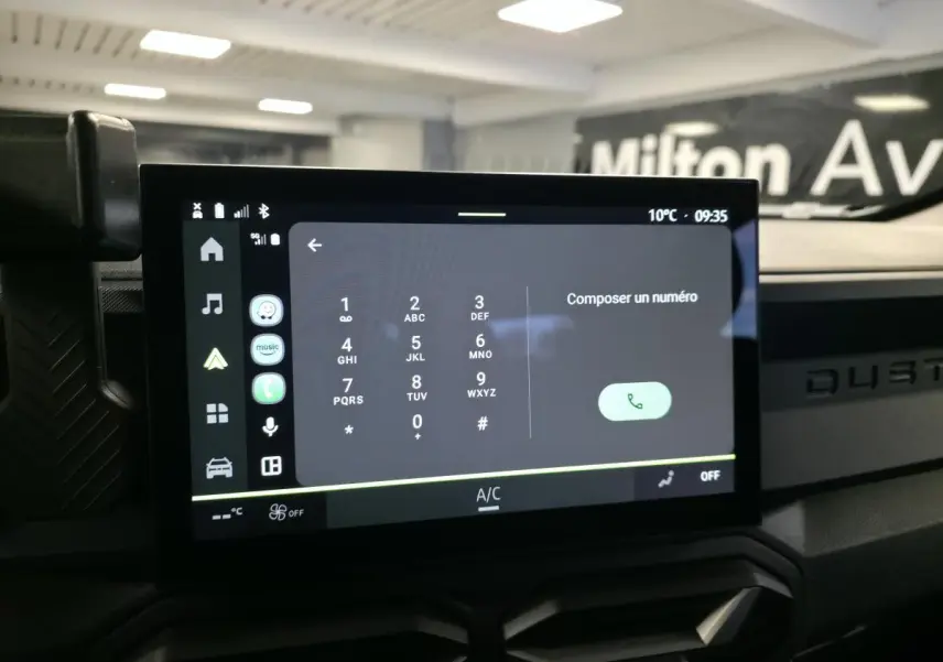 Écran tactile central affichant le clavier téléphonique dans l’habitacle du Dacia Duster noir, vue de face.