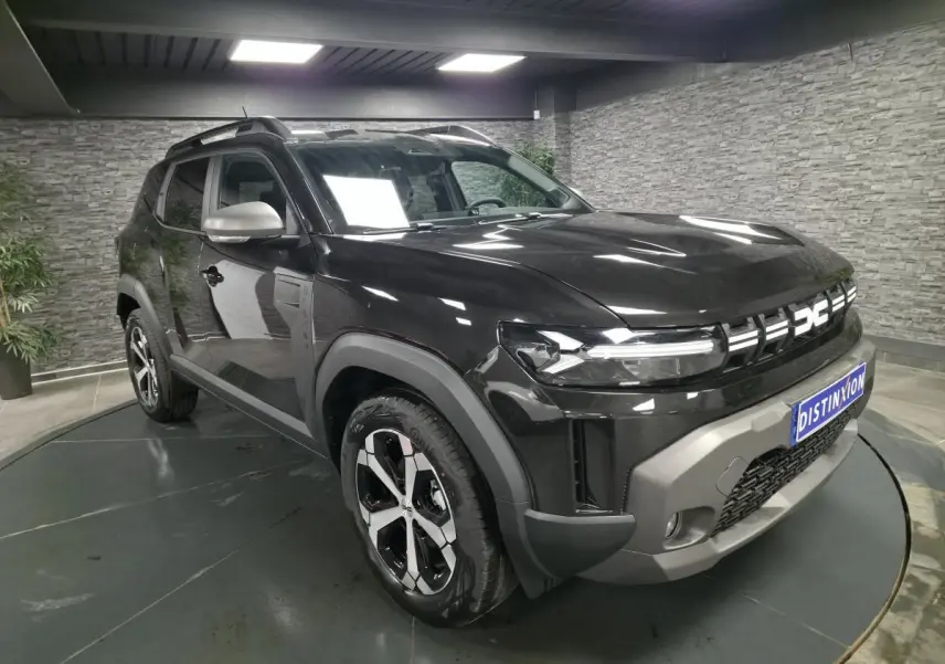 Dacia Duster 1.6 Hybrid noir nacré en 3/4 avant droit, avec jantes alliage 18 pouces et barres de toit noires.
