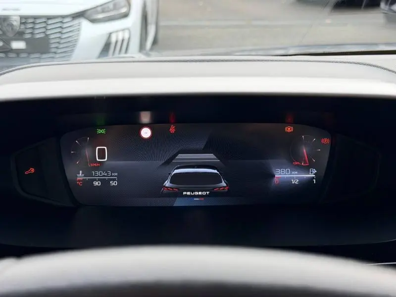 Affichage numérique du tableau de bord de la Peugeot 308 gris, vue frontale centrée sur l'écran de conduite.