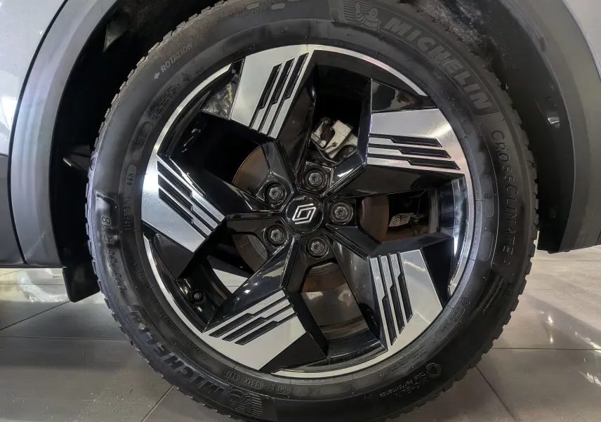 Gros plan sur la jante bicolore noire et argent du Renault Symbioz gris Cassiopé, avec pneu Michelin CrossClimate visible.