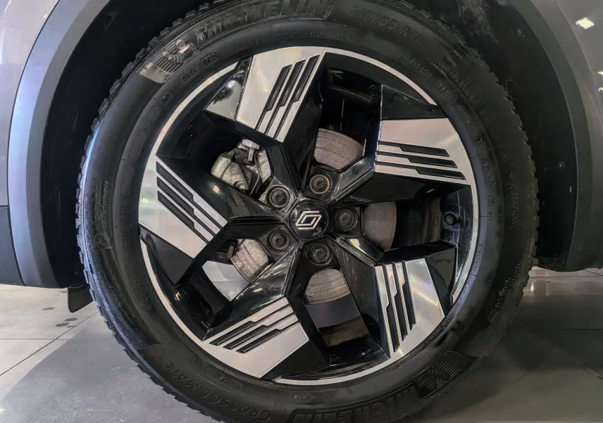 Gros plan sur la jante noire et argentée avec logo Renault du Renault SYMBIOZ gris Cassiopé, roue avant droite.