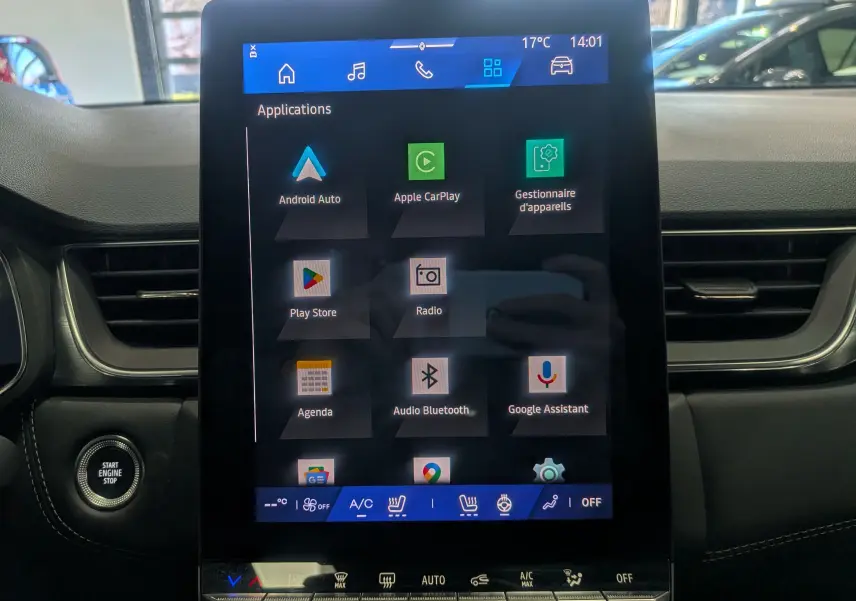 Vue intérieure centrée sur l'écran tactile du tableau de bord du Renault Symbioz gris Cassiopé, affichant les applications connectées.