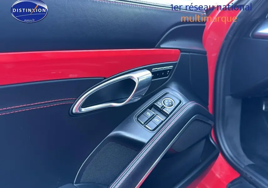 Détail de la porte avant droite rouge de Porsche 911 (991) Carrera 4 PDK avec garniture cuir noire et surpiqûres rouges.