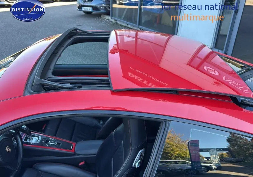 Vue de dessus côté gauche d'une Porsche 911 rouge (991) avec toit ouvrant électrique partiellement ouvert.