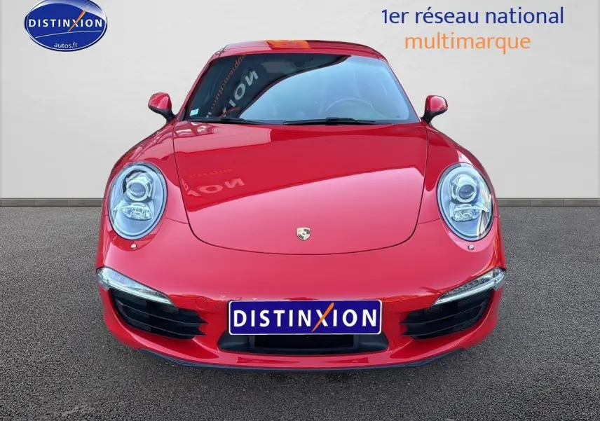 Vue frontale d'une Porsche 911 (991) Carrera 4 PDK rouge avec phares ronds et calandre basse noire.