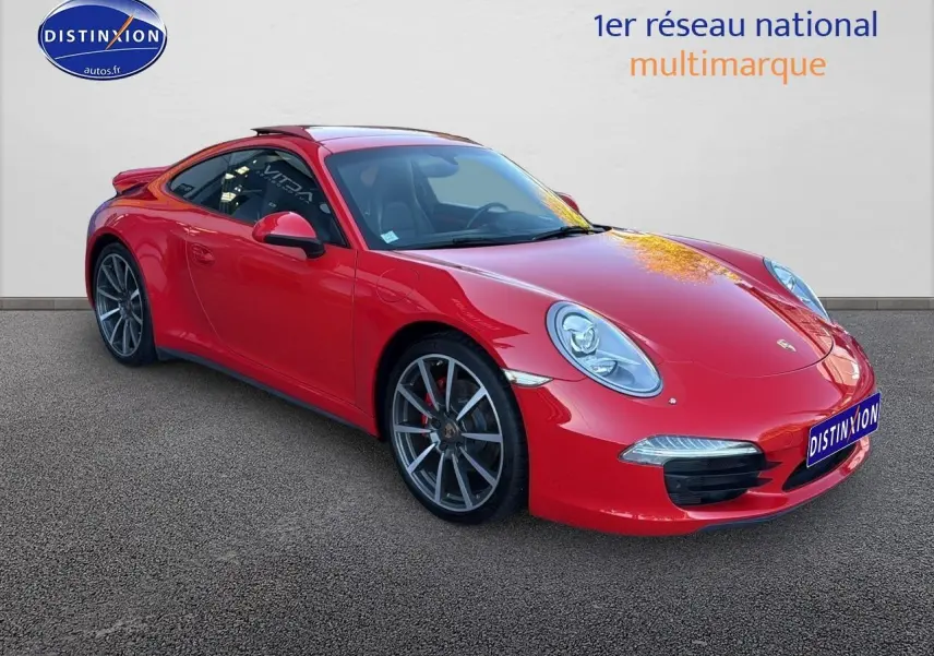 Porsche 911 (991) Carrera 4 rouge vue 3/4 avant droit avec jantes alu et becquet arrière visible.