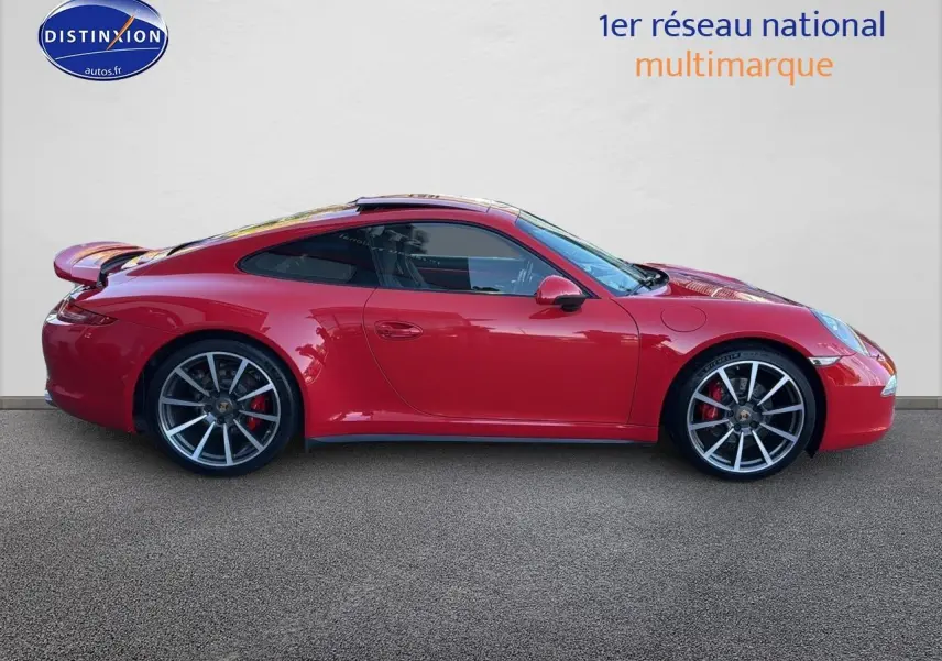 Profil droit d'une Porsche 911 (991) Carrera 4 PDK rouge avec jantes alu et becquet arrière déployé.