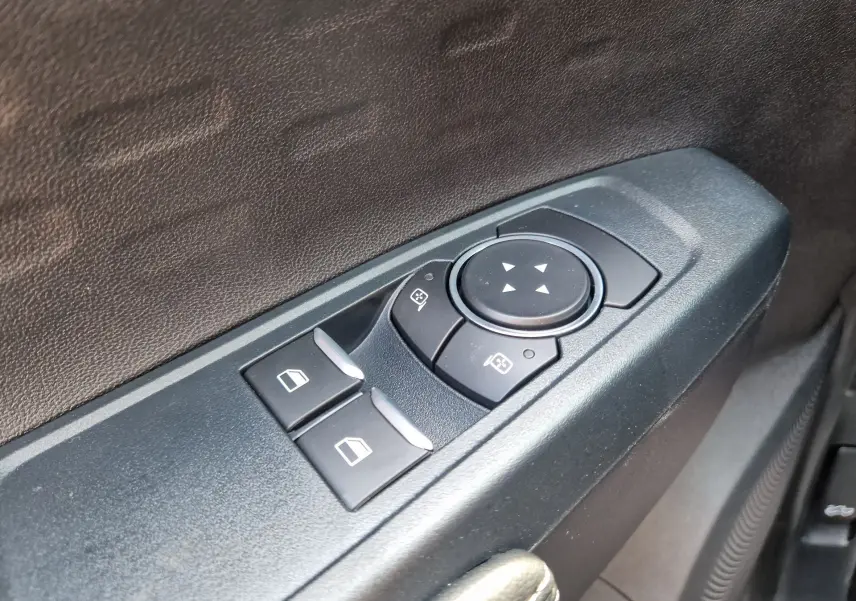 Détail des commandes de lève-vitres et réglage des rétroviseurs sur la portière côté conducteur du Ford Ranger Super Cabine gris carbone.