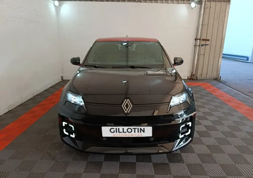 Vue avant d'une Renault R5 électrique 2024 noire avec toit rouge et feux LED allumés en intérieur.