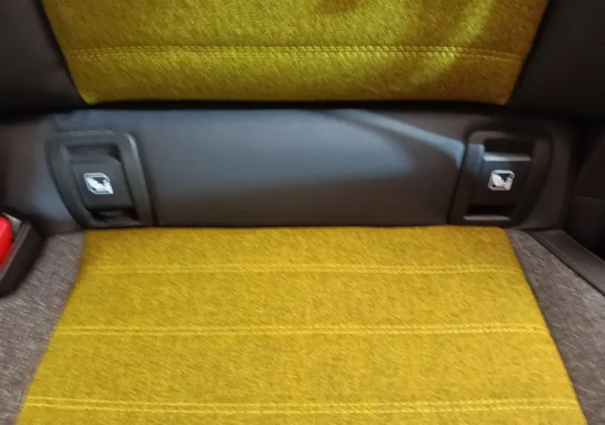 Gros plan sur la banquette arrière jaune moutarde de la Renault R5 Iconic Cinq 2024 avec attaches Isofix visibles.