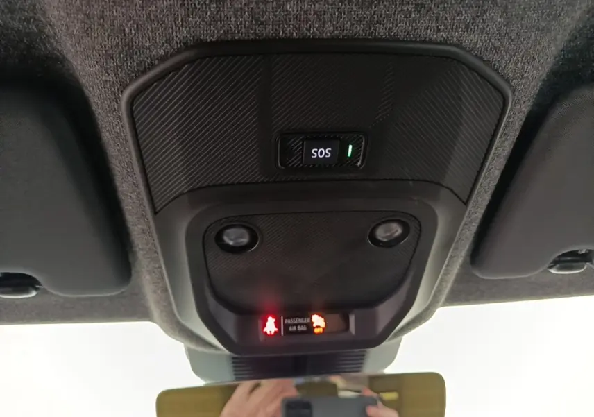 Vue intérieure du plafonnier avec bouton SOS et voyants d'airbag du Renault R5 Iconic 2024, finition carbone.