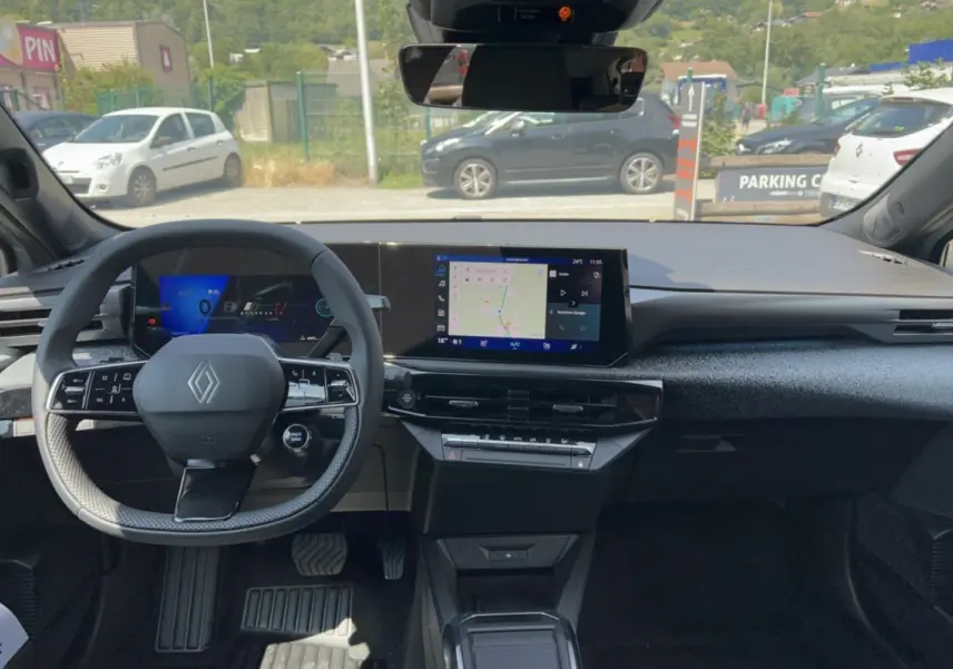 Vue intérieure avant de la Renault Clio gris rafale 2026, avec tableau de bord numérique et écran central tactile.