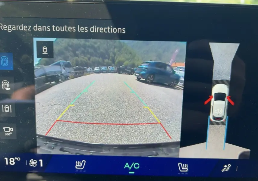Écran de caméra 360° de la Renault Clio gris rafale montrant la vue arrière en stationnement avec repères colorés.