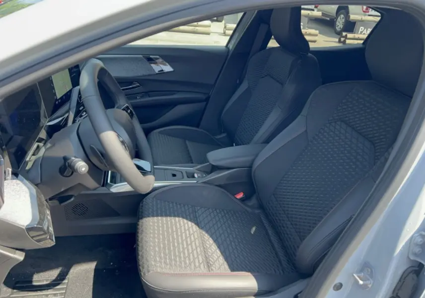 Vue intérieure côté conducteur de la Renault Clio 6 TCE 115 EDC Techno Plus avec sièges noirs texturés et volant multifonctions.