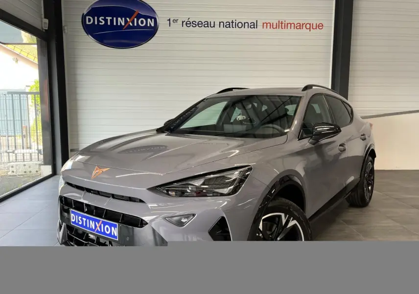 Vue 3/4 avant droite du CUPRA Formentor gris clair 2025 avec jantes alliage et logo CUPRA cuivré sur le capot.