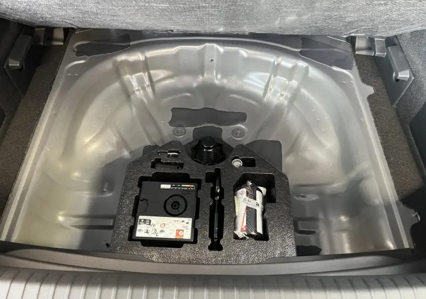 Vue plongeante sur le coffre ouvert du CUPRA Formentor gris clair, montrant le compartiment rangement sous plancher.