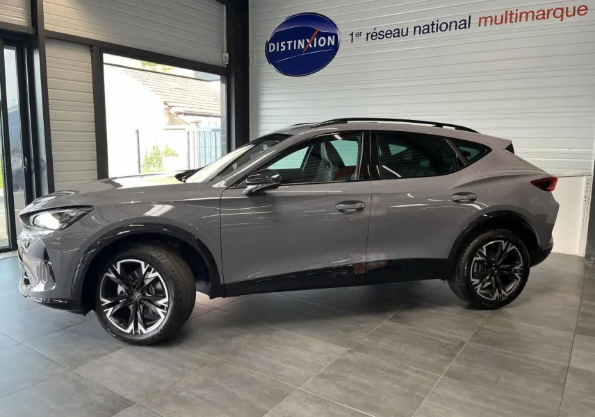 Vue de profil côté gauche d'un CUPRA Formentor gris clair avec jantes alliage noires et détails noirs contrastants.