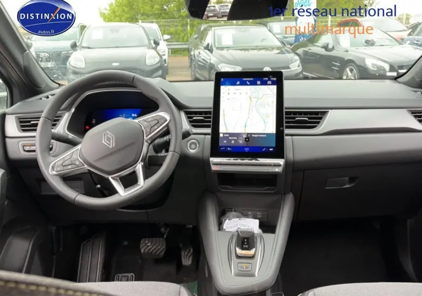 Vue intérieure avant de la Renault Symbioz gris schiste, avec écran tactile vertical et volant multifonctions.