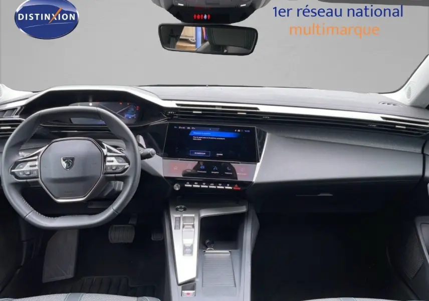 Vue intérieure frontale du tableau de bord et volant de la Peugeot 408 gris, avec écran tactile central et commandes modernes.