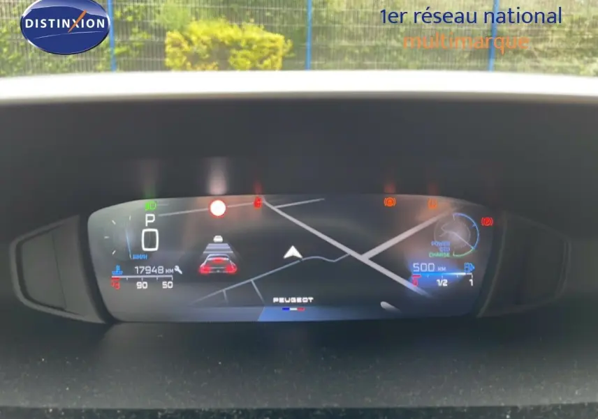Tableau de bord numérique de Peugeot 408 gris, affichant la vitesse, navigation et alertes, vue frontale intérieure.