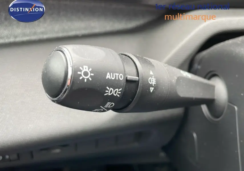 Gros plan sur la commande des feux automatique à gauche du volant dans un Peugeot 408 gris Selenium 2025.