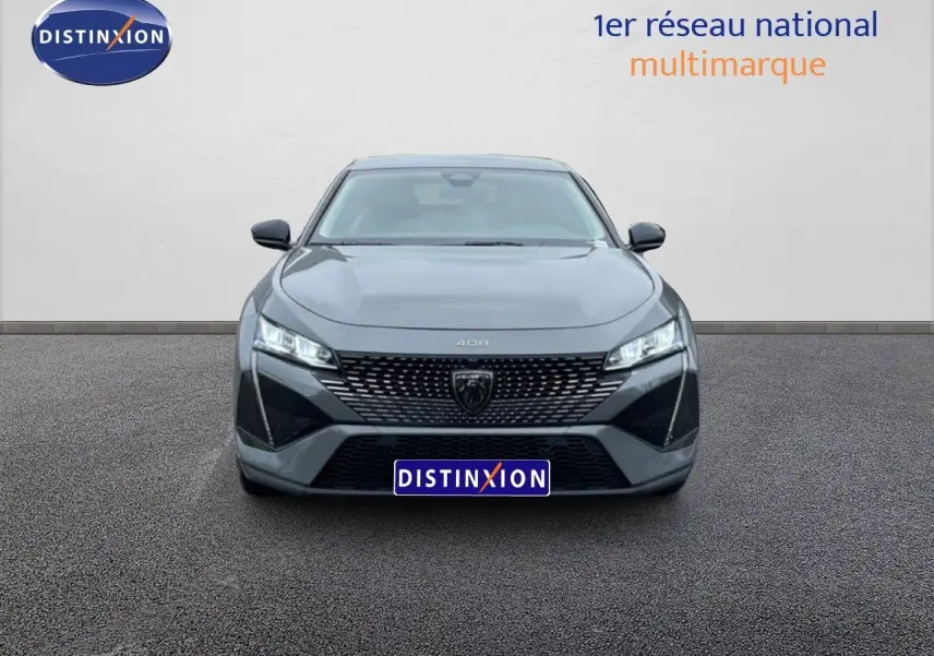 Vue frontale d'une Peugeot 408 gris selenium metal avec calandre noire et phares LED allumés.