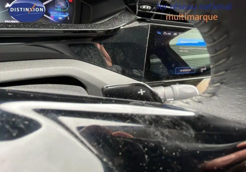 Vue rapprochée du tableau de bord et du volant noir du Peugeot 408 gris Selenium, avec affichage numérique et commandes au volant.