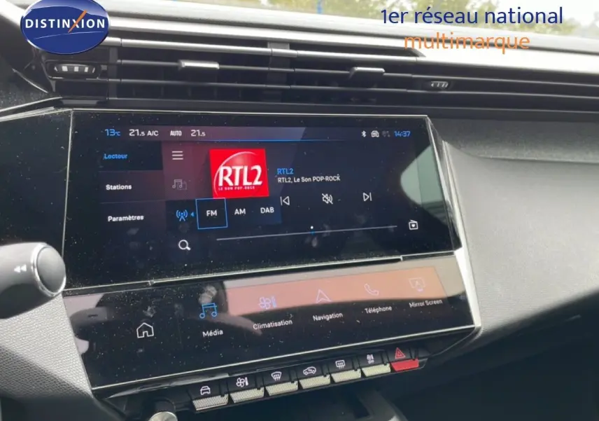 Vue rapprochée de l’écran tactile central du tableau de bord du Peugeot 408 gris, affichant la radio RTL2.