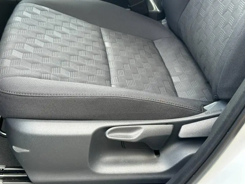 Gros plan sur le siège avant droit en tissu gris à motifs géométriques de la Toyota Yaris 116h Dynamic 2025 Blanc Lunaire.