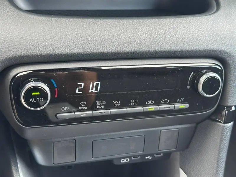 Panneau de commande de climatisation automatique de la Toyota Yaris 116h Dynamic 2025, affichant 21°C et réglages activés.