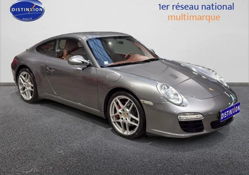 Porsche 911 (997) carrera pdk gris vue 3/4 avant droit, jantes alu et phares bi-xénon visibles.
