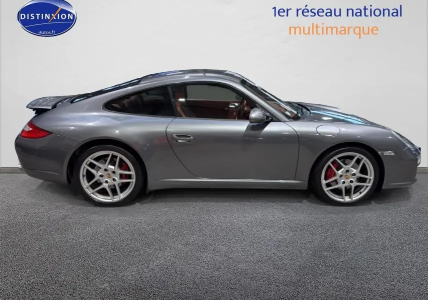 Profil droit d'une Porsche 911 (997) Carrera PDK gris métallisé avec jantes alu et toit ouvrant électrique visible.