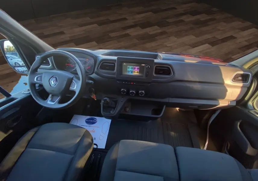 Vue intérieure avant du Renault Master blanc 2023, tableau de bord avec écran tactile et volant multifonction.