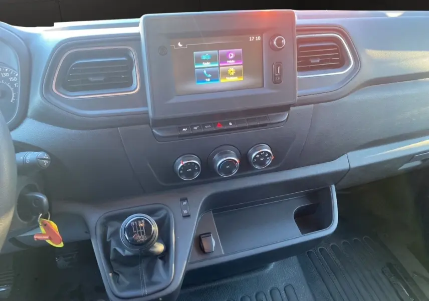 Vue intérieure du tableau de bord du Renault Master blanc 2023, avec écran tactile et levier de vitesse manuel visible.