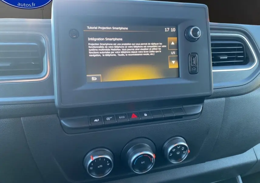 Tableau de bord du Renault Master 2023 avec écran tactile central affichant un tutoriel smartphone, boutons de commande et réglages climatisation.