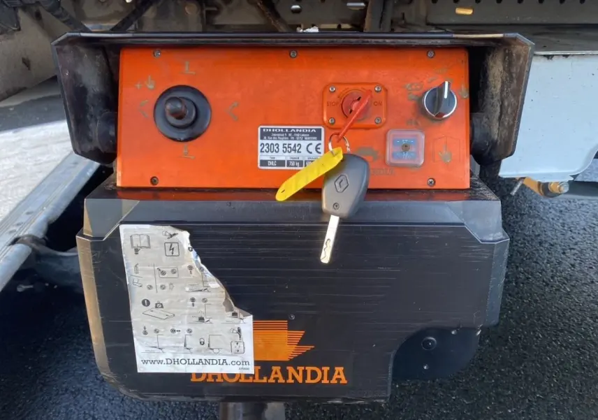 Gros plan sur le boîtier de commande orange et noir du hayon arrière du Renault Master blanc, avec clé insérée.