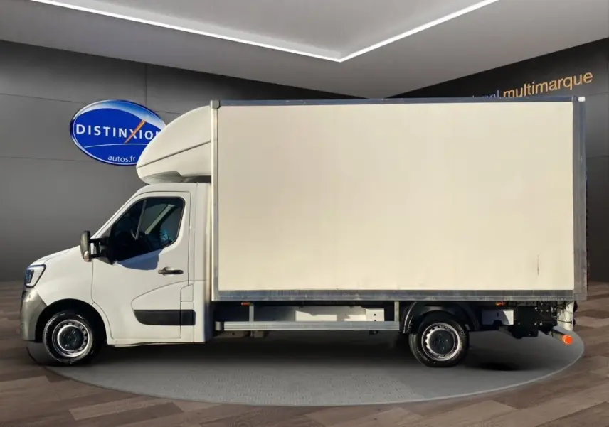 Vue latérale gauche d'un Renault Master blanc avec caisse hayon, présenté en intérieur sur plateau tournant.