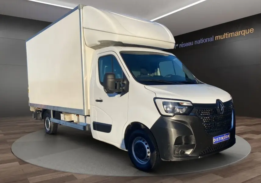 Renault Master blanc en 3/4 avant droit, châssis cabine avec grande caisse et hayon élévateur visible.
